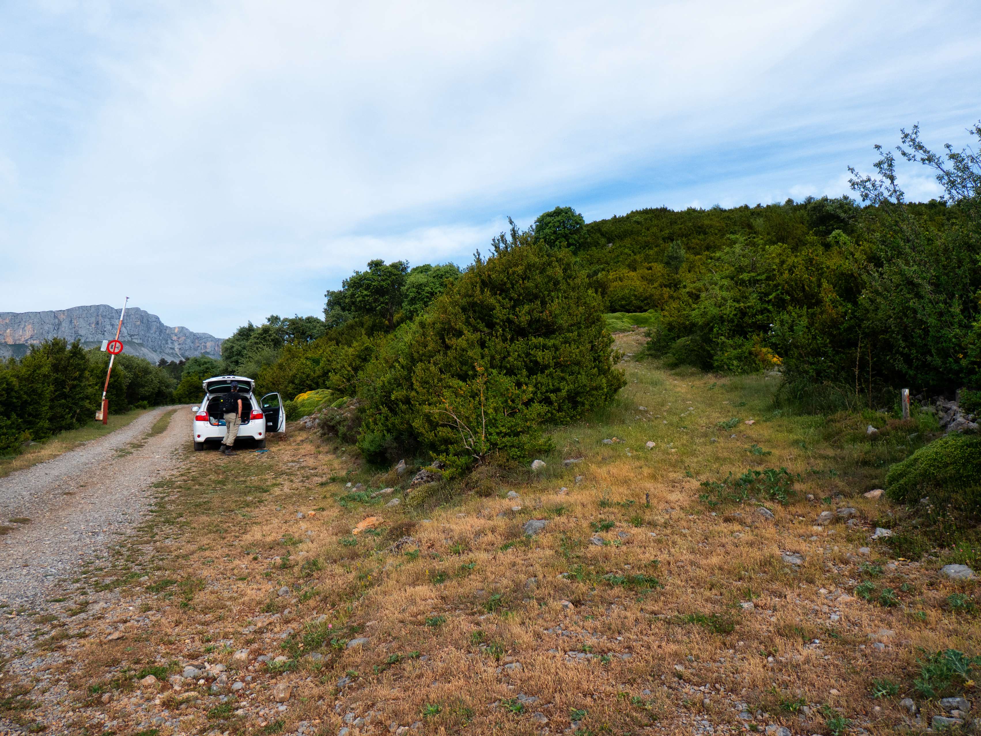 Aunque la barrera de la pista está levantada, no nos fiamos y aparcamos el coche justo antes, para evitarnos problemas a la vuelta. Empezamos retrocediendo una decena de metros para tomar un camino que se abre a mano derecha, señalizado con postes de GR.