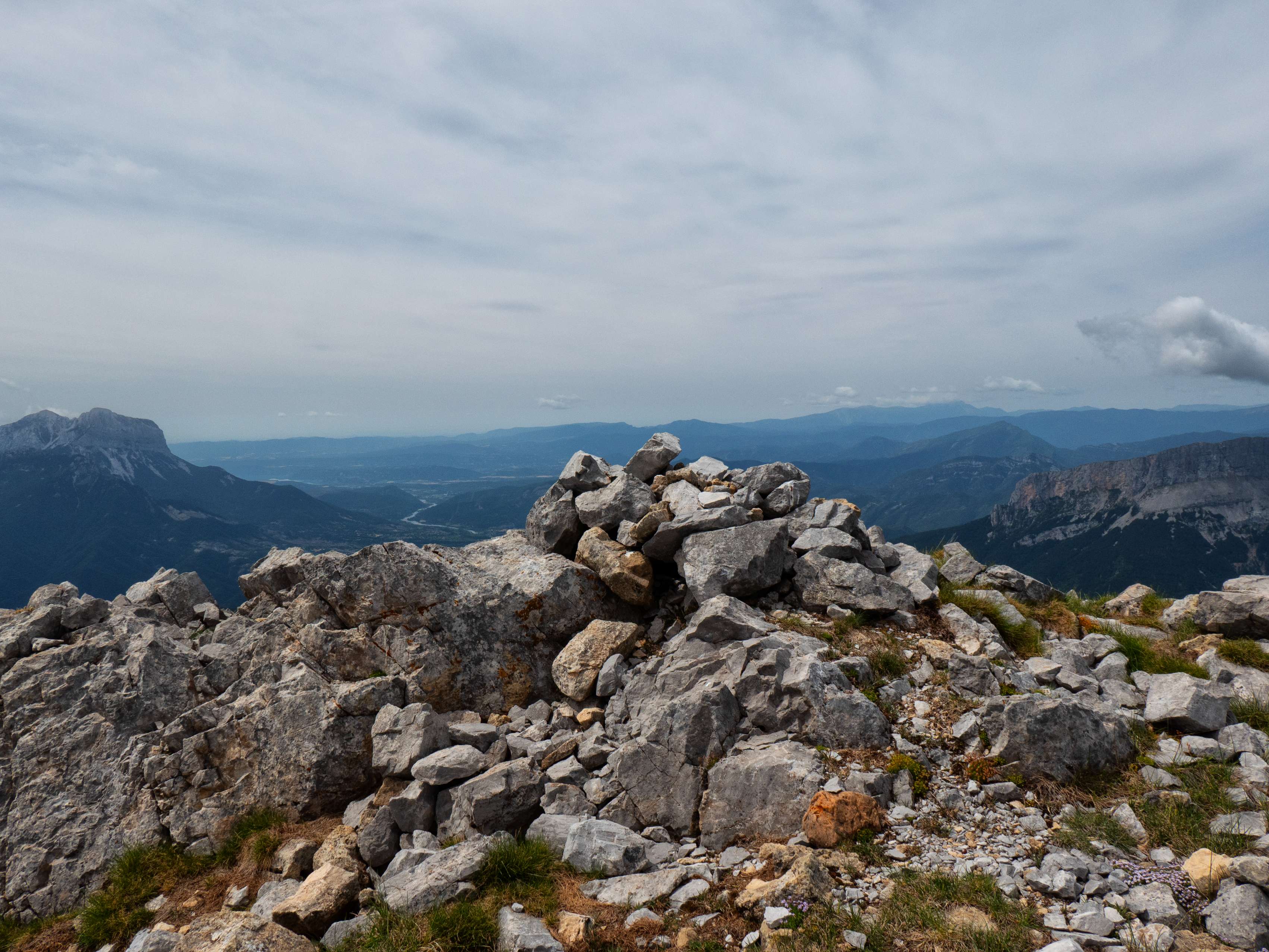 Después de una breve cresta, coronamos la Peña Altura, donde encontramos un hito formado por la abundante piedra caliza que jalona esta cumbre.