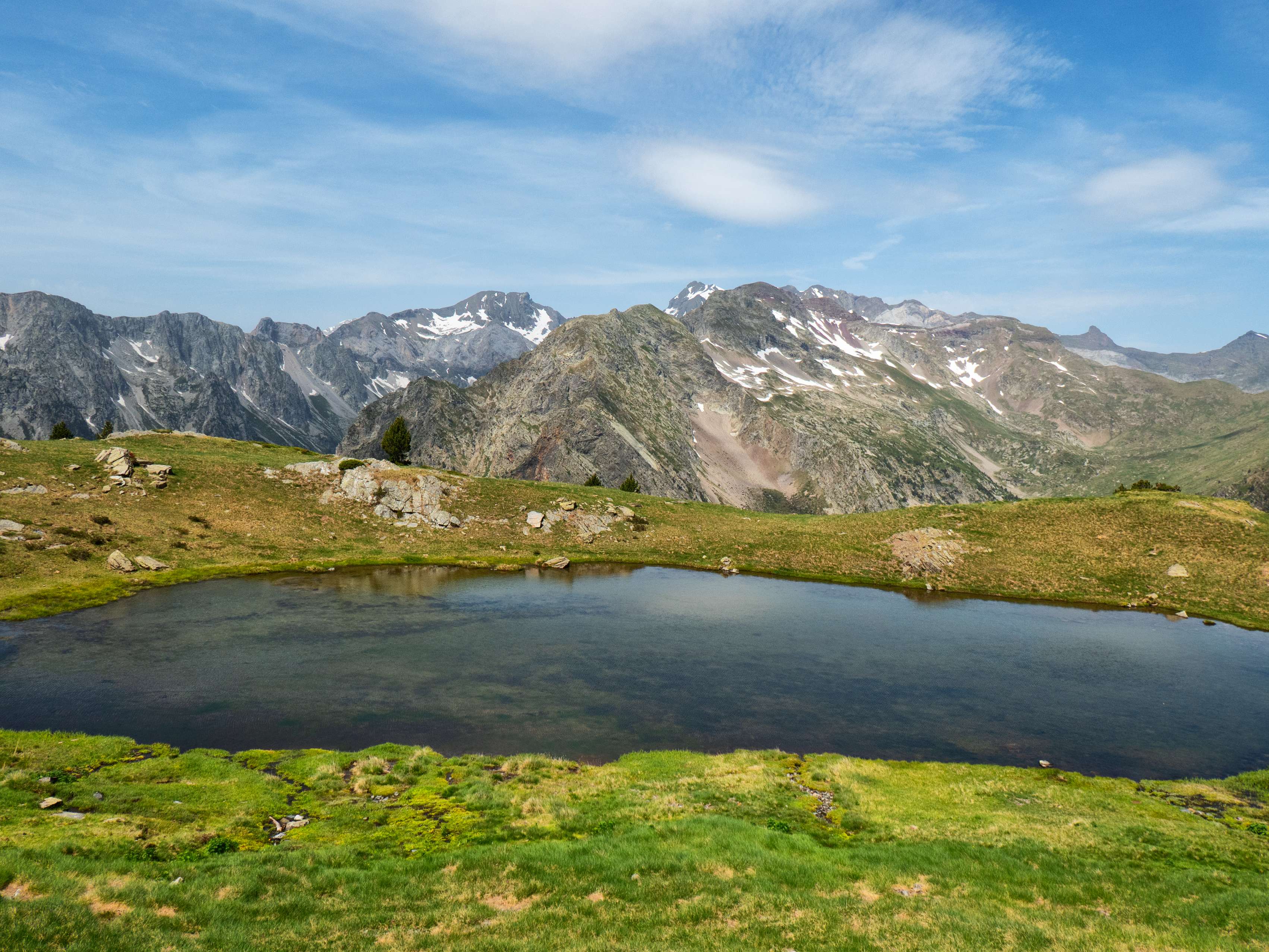 Durante esta travesía, obtenemos esta fotogénica estampa del ibón, con las grandes cumbres de la Múnia en el horizonte.