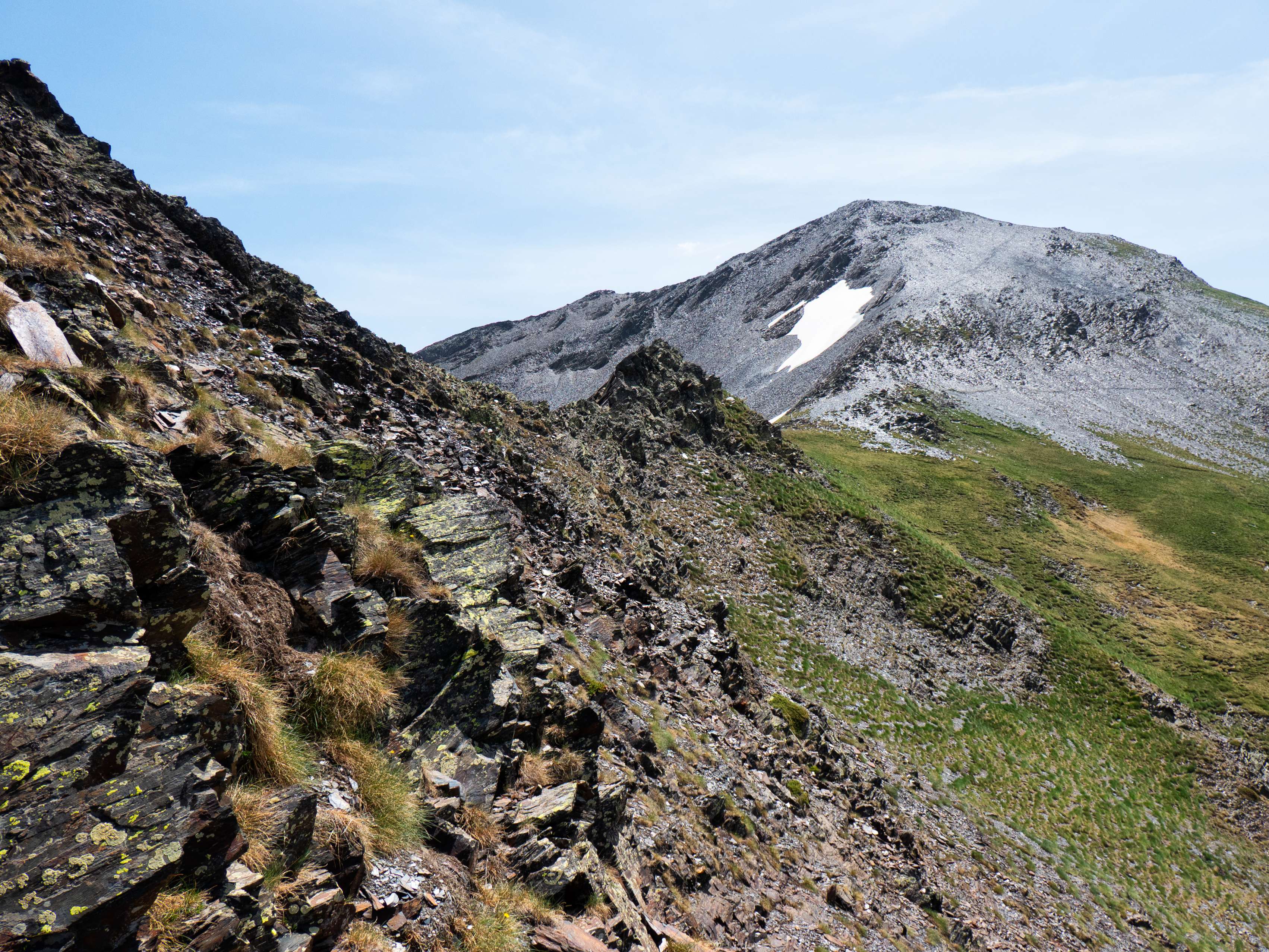 Sin embargo, el sendero desaparece al entrar en una ladera metamórfica de piedra muy inestable y descompuesta, que nos cuesta lo suyo de atravesar, debiendo realizar alguna que otra trepada por terreno no demasiado cómodo.