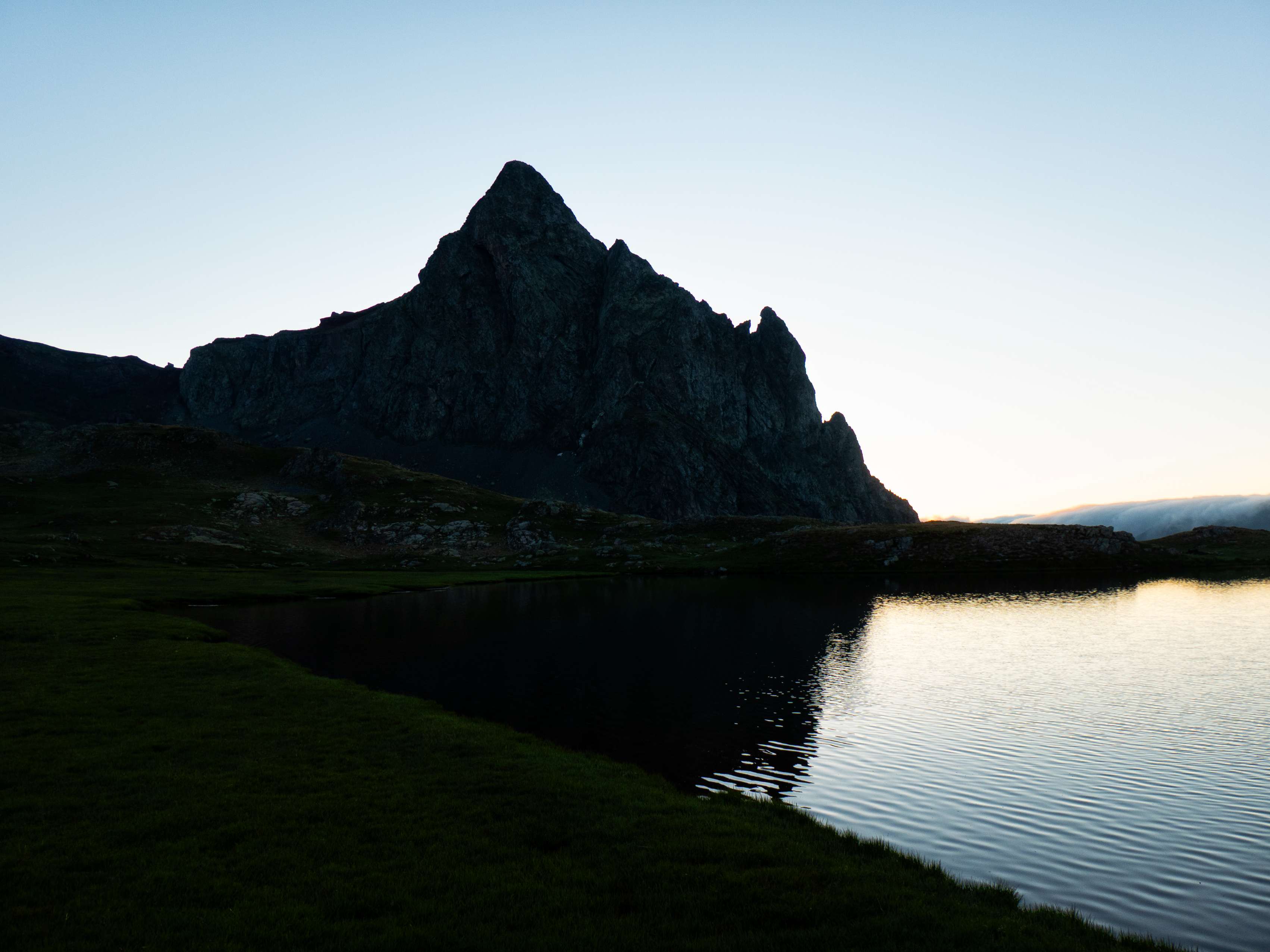 Las oscuras torres del Anayet también se reflejan en las calmadas aguas del lago. Parece imposible que exista una vía relativamente sencilla para ascender a esta afilada cima.