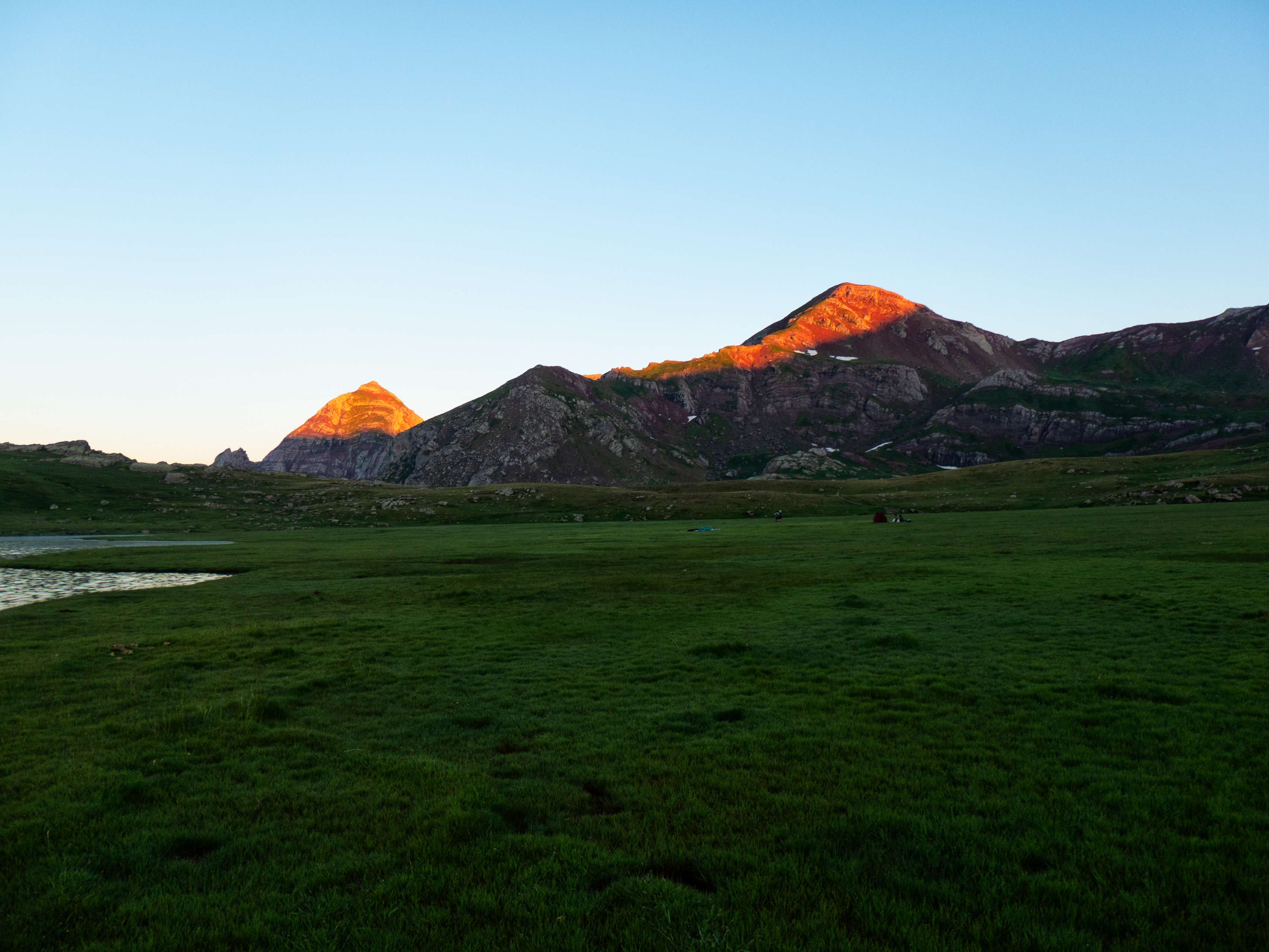 Con los últimos y más débiles rayos de sol tocando las cimas de Culivillas y Arroyeras, nos dirigimos hacia las colinas de hierba situadas al sur del lago principal, donde buscamos un lugar llano y cómodo donde poner el saco y pasar la noche.
