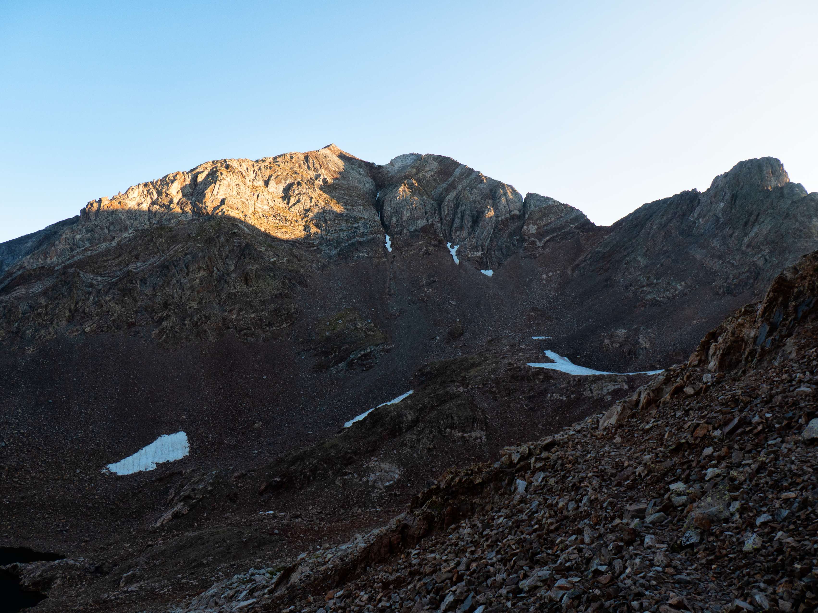 Desde el Collado de Pondiellos tenemos también una primera vista de los señores de Panticosa, los coloridos y verticales <a href="https://triptomontes.com/circular-a-los-picos-del-infierno-desde-los-banos-de-panticosa-por-los-ibones-azules-y-retorno-por-pondiellos/">Picos del Infierno</a>, con su canal sur, por la izquierda de la cual se puede descender aunque parezca imposible, separando el Infierno Central del Oriental. El Arnales, uno de los tresmiles más bajos del Pirineo al comprobarse que supera la cifra mágica por apenas un metro, ofrece también una estampa bastante atractiva desde aquí.