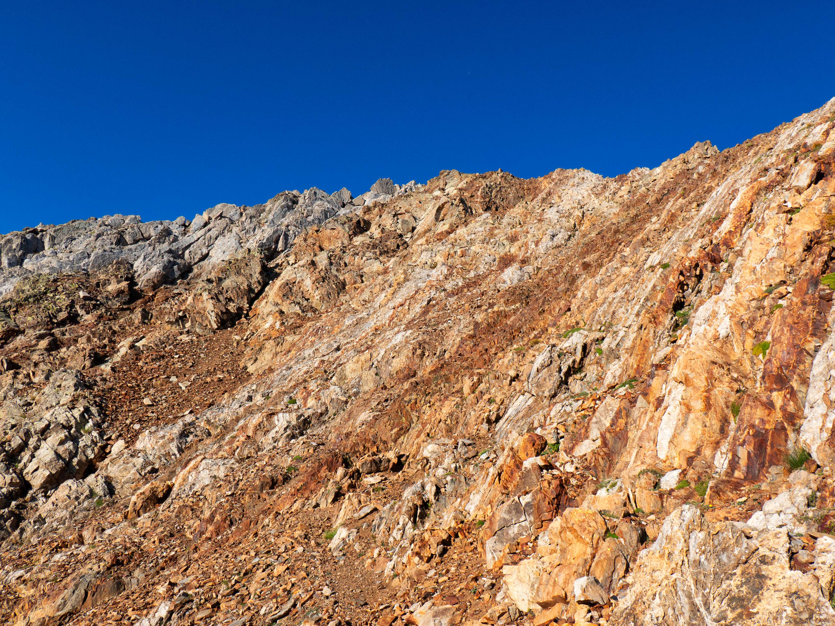 Después de unos metros por el filo debemos flanquear por la izquierda un resalte vertical y nos adentramos nuevamente en la descompuesta ladera bajo la Aguja de Pondiellos, que afortunadamente queda cercana. Trepando por donde mejor nos parece y, sobre todo, por donde parece que la roca sea más firme, vamos remontando los últimos 50 metros hasta alcanzar...