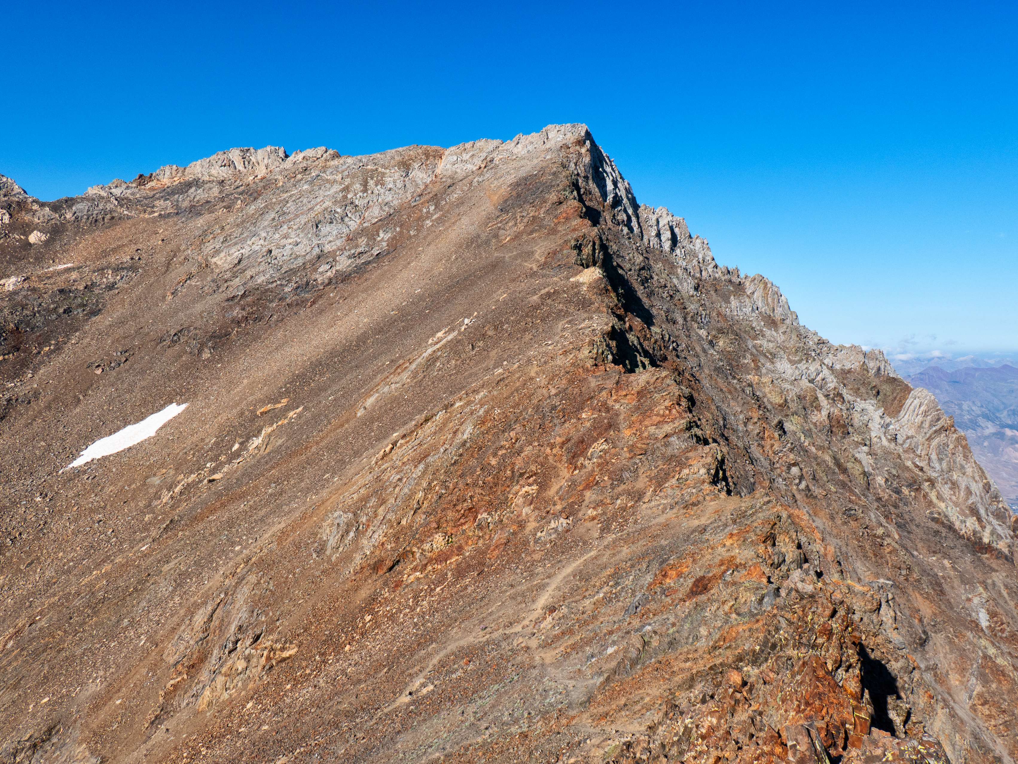 Descendiendo con menos rapidez de lo que nos gustaría por lo descompuesto del terreno, ganamos finalmente el collado entre el Garmo Negro y el Algas N, que muestra dos vertientes bien diferenciadas: empinada y terrosa su cara sur; un vertical abismo, su cara norte. Un trazo de sendero salva mediante zigzags los 50 metros por pedrera previos a...