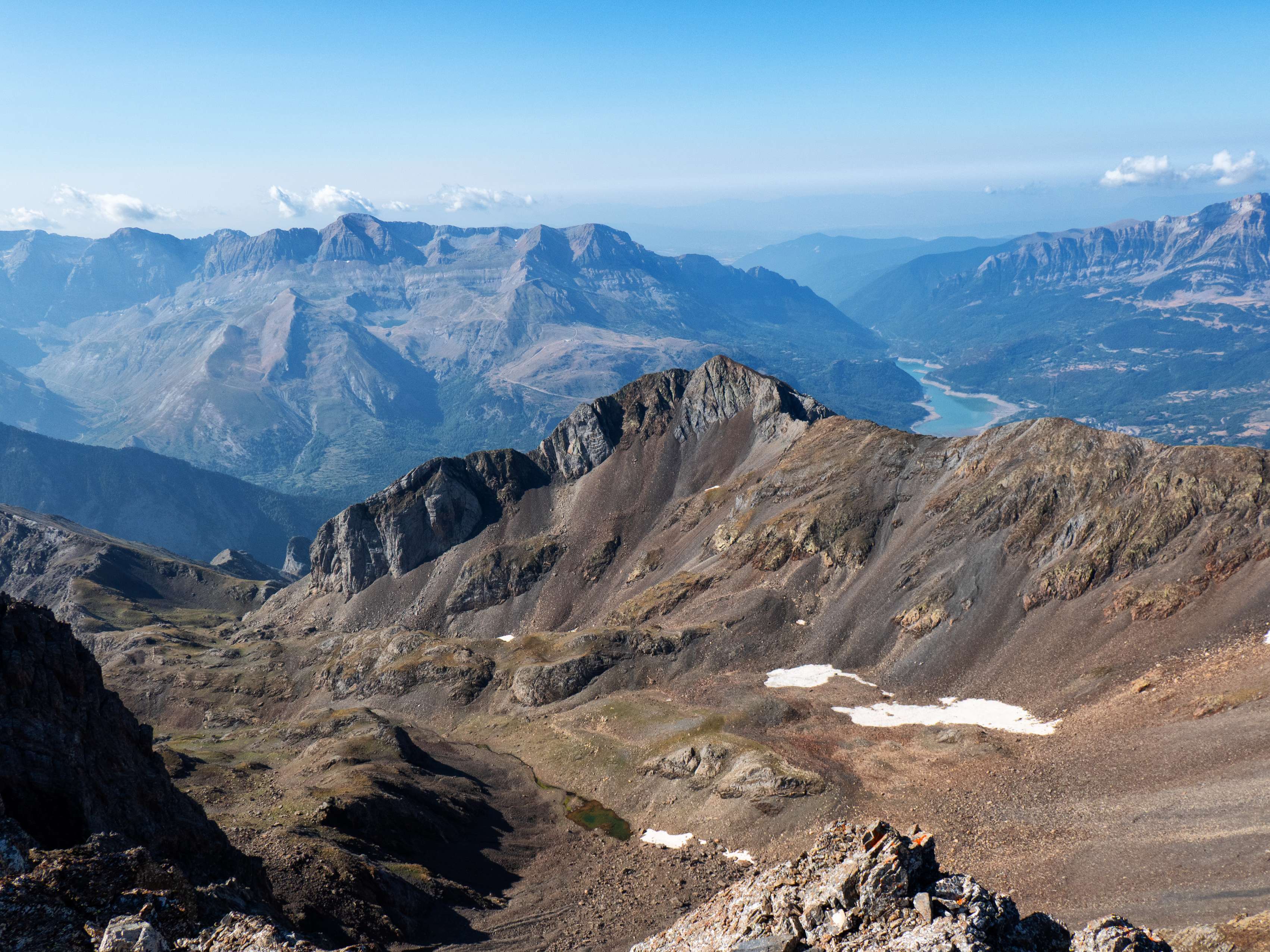 Prolongando la cresta que sale del Arna hacia el sur, vemos el pico de Feniás, tras el cual vemos la entrada al valle de Tena, representada por el embalse de Búbal, bien delimitada por las sierras de Tendeñera y de la Partacúa.