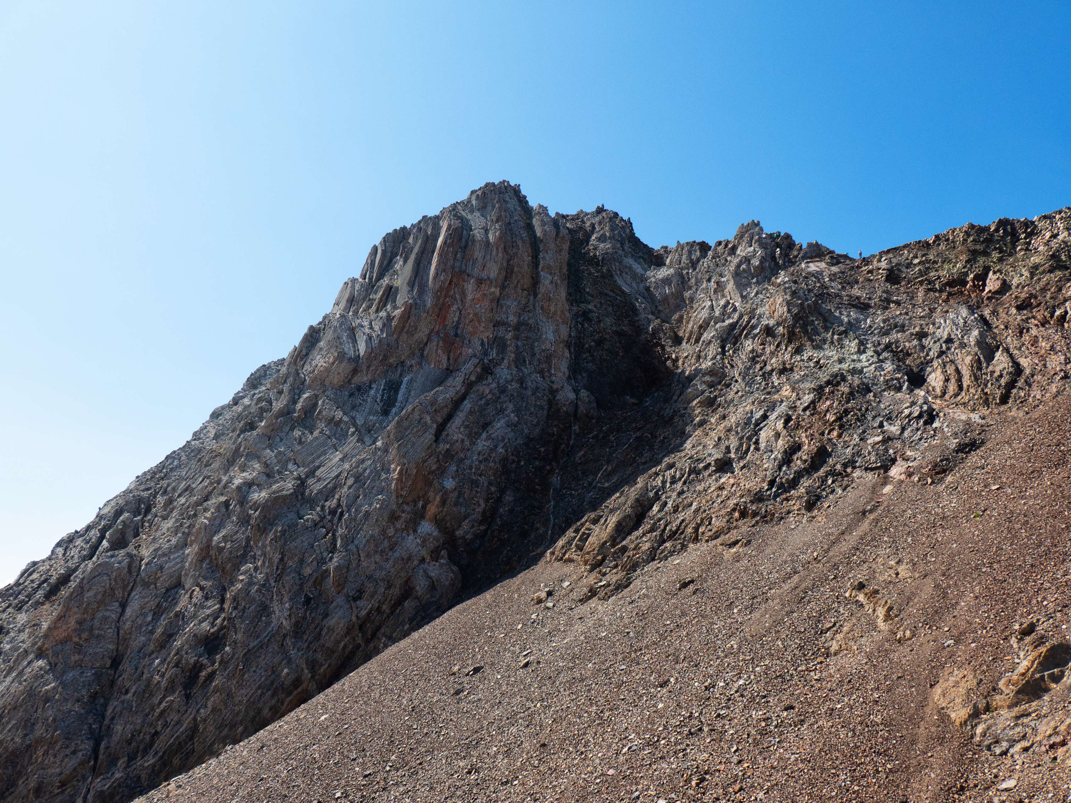 A nuestra derecha dejamos el terrible paredón del Argualas. Si nos fijamos, en la parte derecha de la cresta, observamos a un montañero plantado sobre la brecha que permite el acceso a esta cima.