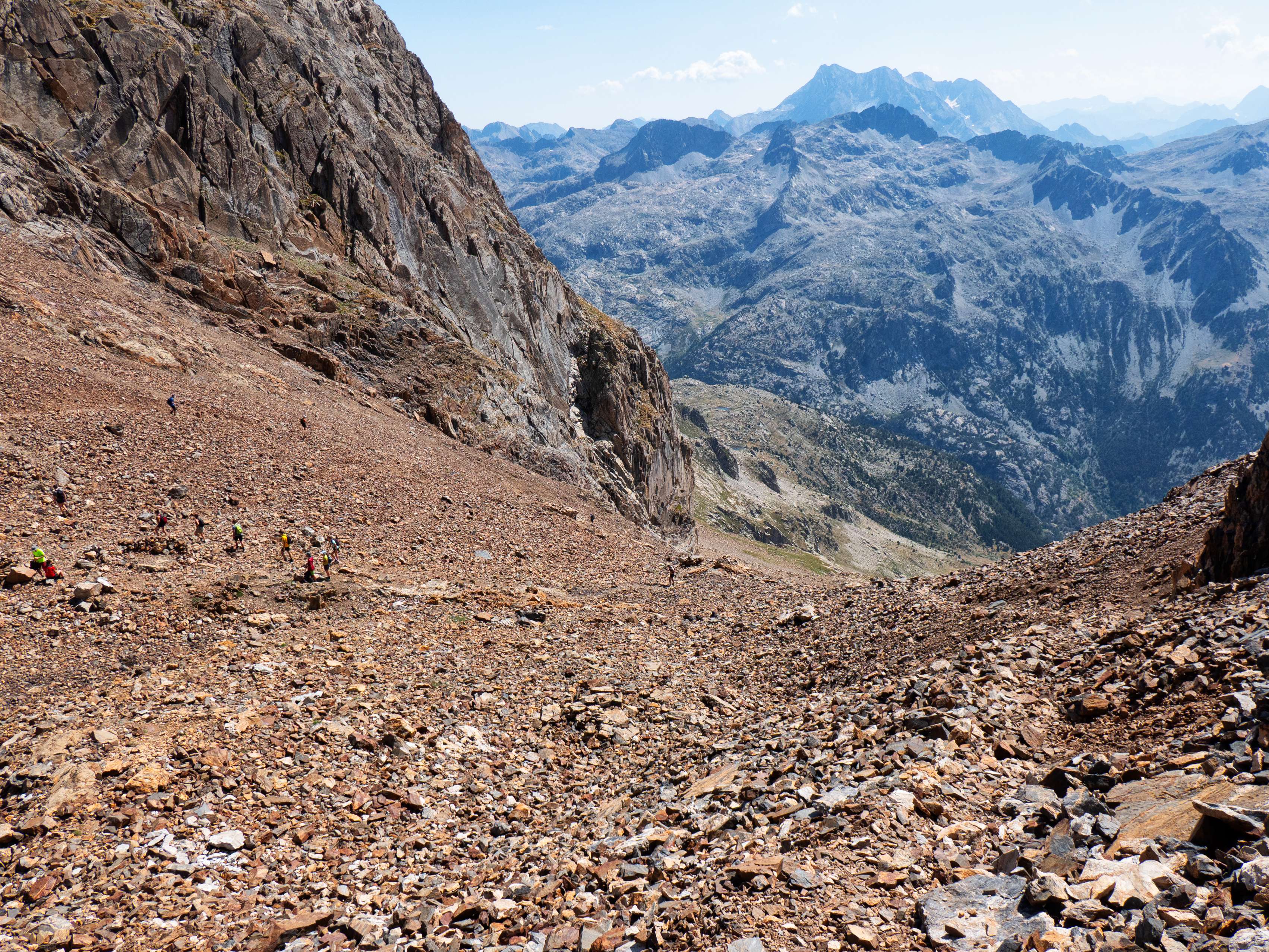 Después de atravesar la loma, el sendero nos lleva a su lado opuesto, donde enlazamos con el sendero de la vía normal al Garmo Negro, abarrotado de gente. En este punto, el riachuelo que se nutre de los neveros del circo forma una serie de cascadas en un pequeño resalte, que el sendero supera mediante zigzags bastante incómodos por la piedrecilla que cubre la ladera.